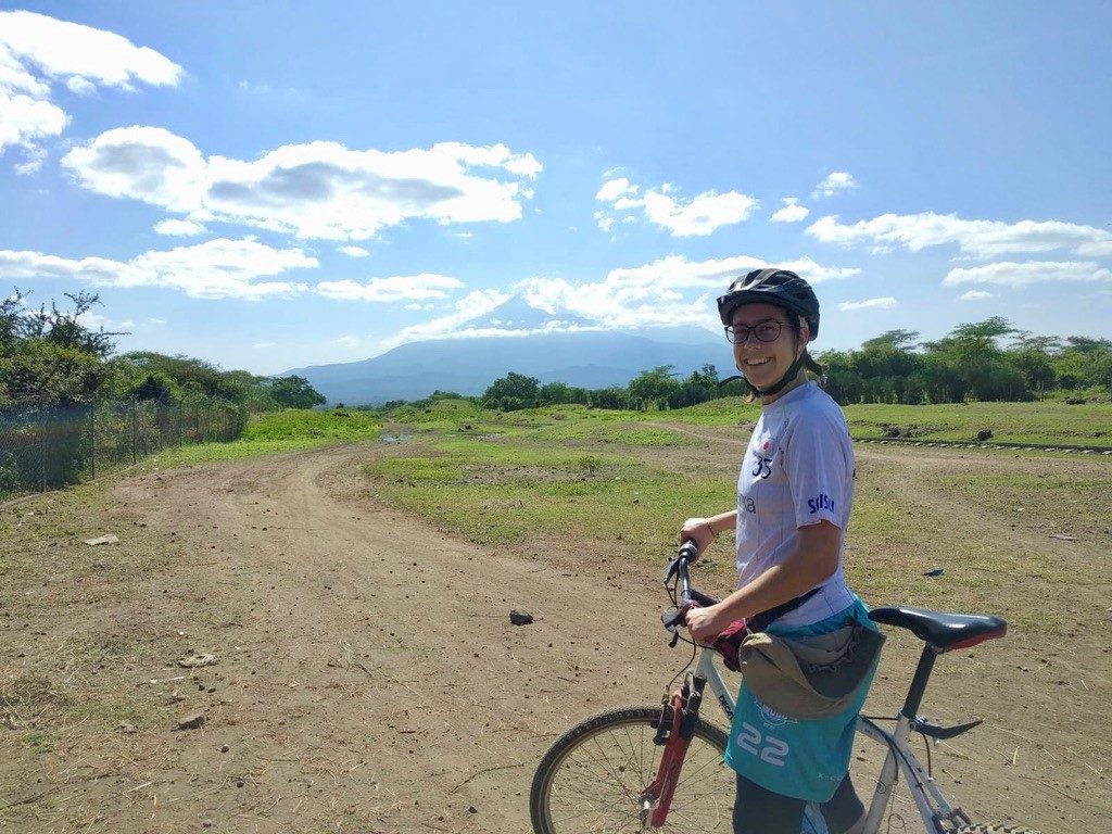 Photo of Kelsey Bilek on a bike with Mt Meru in the background