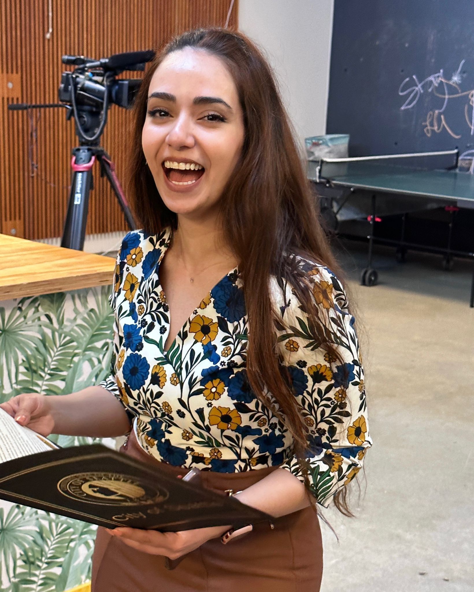 Lamis smiling holding her letter of recognition from the Mayor of Seattle.