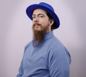 Photo of Vecksle Drake looking at the camera with a blue hat.